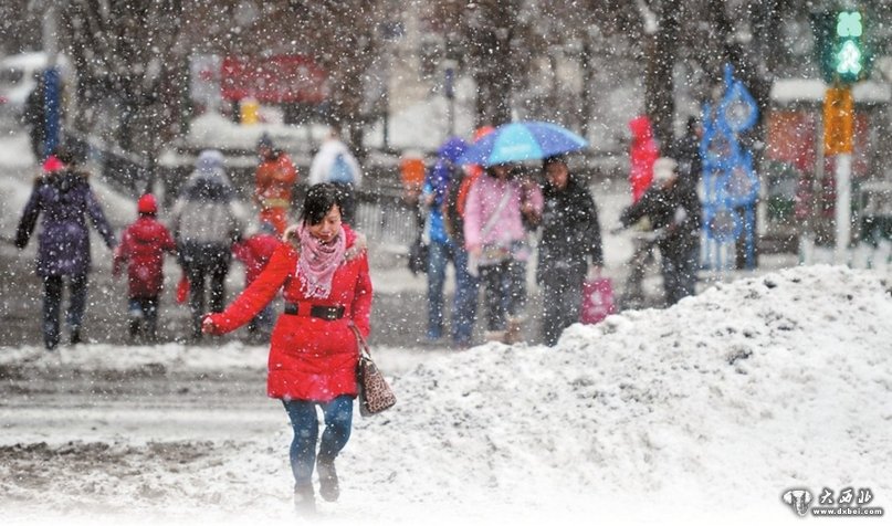 图为2月13日16时30分，在水磨沟区南湖南路，市民穿过覆盖积雪的路口。